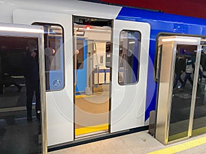 High speed train with opened automatic doors at the platform railway station