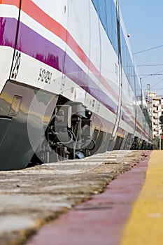 High speed train parked on the track awaiting its departure seen from a low plane at the platform