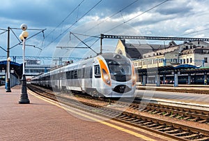 High speed train at the railway station at sunset