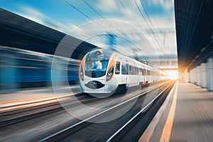 High speed train at the railway station at sunset