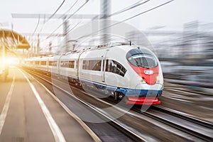 High speed train rides at high speed at the railway station in the city. photo