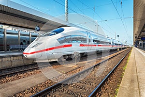 High speed white train on the railway station