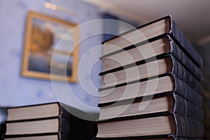 High stack of books on the desk in library