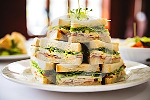 a high stack of cut clubhouse sandwiches for high-tea