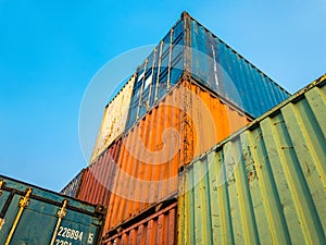 High Stack Towering Containers Box Up To The Blue Sky in Logistic Warehouse. Concept of Cargo