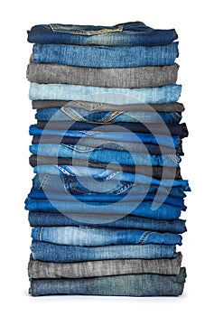 High stack of various shades of blue jeans