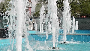 High streams of fountain in centre of small town. Blue water of pool. Sunny day with warm weather in town centre