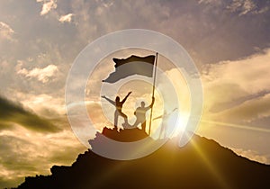 High success, family three silhouette, father of mother and child holding flag of victory on top of mountain, hands up.