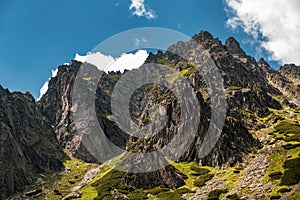 Vysoké Tatry vrchol s modrou oblohou a mraky na pozadí na Slovensku. Turistické stezky pro pěší turistiku v