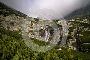 High Tatras, Mlynicka valley, Waterfall Skok and Strbsky peak on the background: natural scenery at tourism in the Waterfall Skok