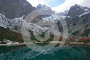 High Tatras and Zelene Pleso Green water lake with Belianske Tatry background, Chata pri Zelenom Plese Slovakia. Autumn with snow