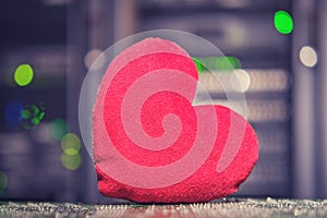 High tech and heart as a symbol of love on a bokeh background from lamps of server equipment