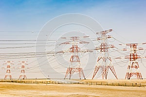 High tension power lines, high voltage line in desert of Oman. Transmission lines, Electricity pylons in red and white photo