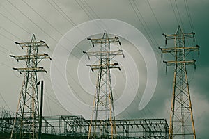 High tension power lines with bruised, storm clouds and dramatic sky