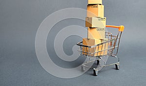 High tower of cardboard boxes on a supermarket trolley. concept of shopping in store. E-commerce, sales and sale of goods through