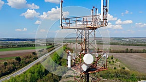 High tower with satellites and cables on a field.