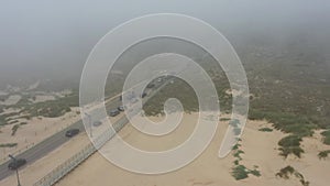 High traffic on road throuth sand dune mystical fog