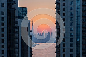 high view of Dubai Downtown cityline with Dubai Creek Canal at sunset time