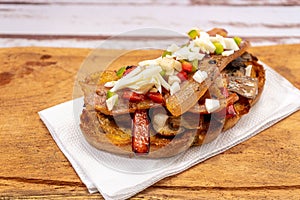 High view of a rustic bread brusquette with mayonnaise, bacon, mushrooms and vinaigrette, drizzled with EVOO or olive oil. Typical photo