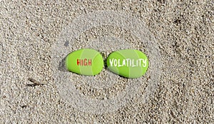 High volatility symbol. Concept words High volatility on beautiful green stone. Beautiful sand beach background. Business high