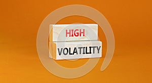 High volatility symbol. Concept words High volatility on beautiful wooden blocks. Beautiful orange table orange background.