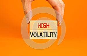High volatility symbol. Concept words High volatility on beautiful wooden blocks. Beautiful orange table orange background.