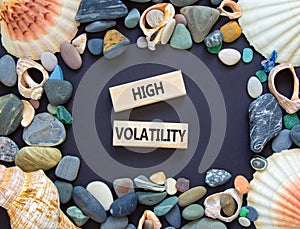 High volatility symbol. Concept words High volatility on beautiful wooden blocks. Sea shell stone. Beautiful black table black