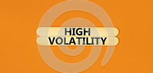 High volatility symbol. Concept words High volatility on beautiful wooden stick. Beautiful orange table orange background.