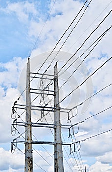 High voltage distribution tower under a cloudy sky