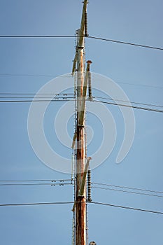 High Voltage Electric Pole with Fuse and Power Cable with bright blue sky as the background