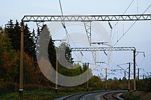 High-voltage electric power lines above the railway. Autumn forest