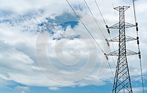 High voltage electric pylon and electrical wire with blue sky and white clouds. Tall electricity pole. Power and energy concept.