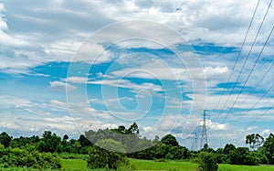 High voltage electric pylon and electrical wire with blue sky and white clouds. Tall electricity pole. Power and energy concept.