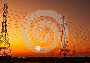 High voltage electric pylon and electrical wire with sunset sky. Electricity poles. Power and energy concept. High voltage grid