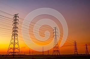 High voltage electric pylon and electrical wire with sunset sky. Electricity poles. Power and energy concept. High voltage grid