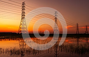 High voltage electric pylon and electrical wire with sunset sky. Electricity poles. Power and energy concept. High voltage grid