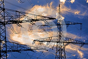 high voltage electric pylons against sky