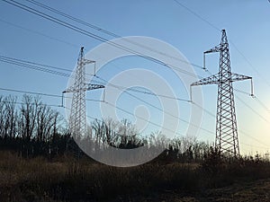 High voltage electric tower against a clear blue sky. High steel pylons of power lines against the sky