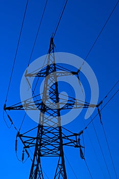High voltage electric tower silhouette on bright blue background
