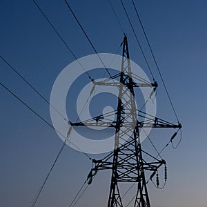 High voltage electric tower silhouette at sunset time and sky on background