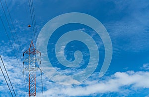 High voltage electric tower and transmission lines. Electricity pylon with blue sky and white clouds. Power and energy