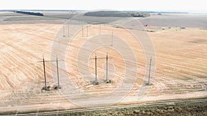 High voltage electric towers in field. Transmission power lines. Electrical equipment and high voltage power line insulators in fa