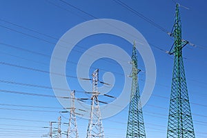 High voltage electric towers under blue sky