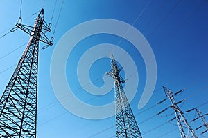 high voltage electric towers under blue sky