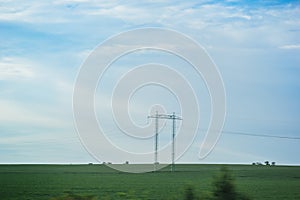 High voltage electric transmission pylon silhouetted. Electricity transmission pylon silhouetted against blue sky. High voltage