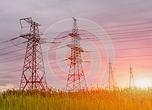 High voltage electric transmission tower at sunset.