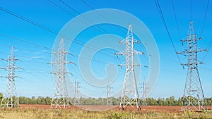 High voltage electric transmission towers. Transmission pylons in industrial landscape. Overhead power lines on the background of