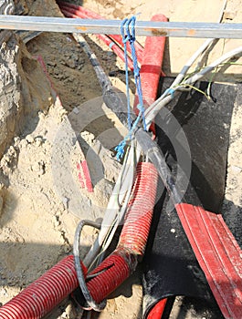 high voltage electrical cables inside the excavation of a road construction site for the repair of the power line