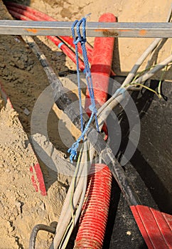 high voltage electrical cables inside the excavation of a road construction site for the repair of the power line