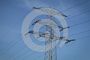 High voltage electrical pylons with wires against the sky